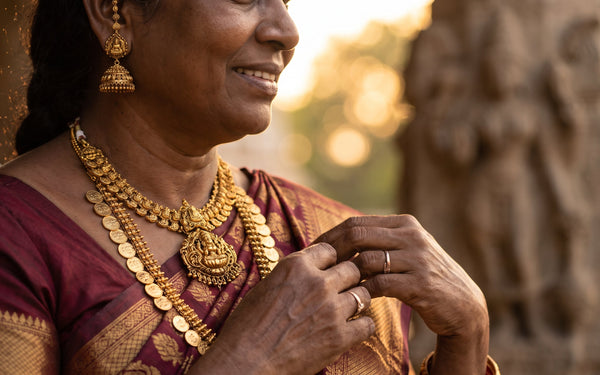 South Indian woman wearing antique gold temple jewellery set with Lakshmi haram, kasu mala and jhumkas in a maroon Kanjeevaram saree